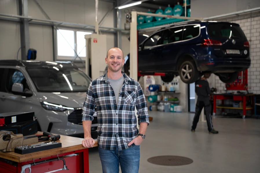 Geschäftsführer der PAROZ AG im Hintergrund Camper und Auto in der Werkstatt